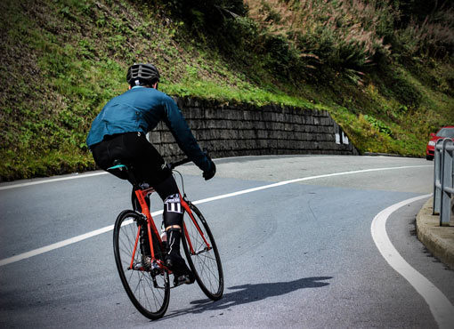cyclist speeding down a mountain road